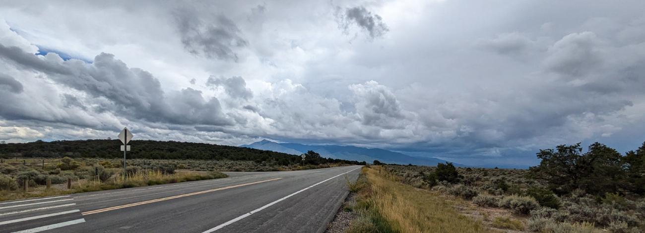 Driving down the Wild Rivers Scenic Backcountry Byway underneath a cloudy sky.
