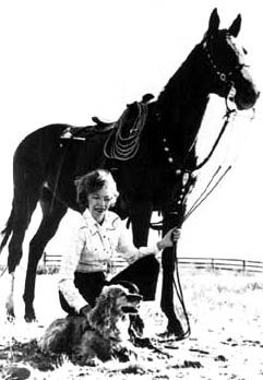 Velma B. Johnson (also known as Wild Horse Annie) kneels next to a horse. BLM photo.