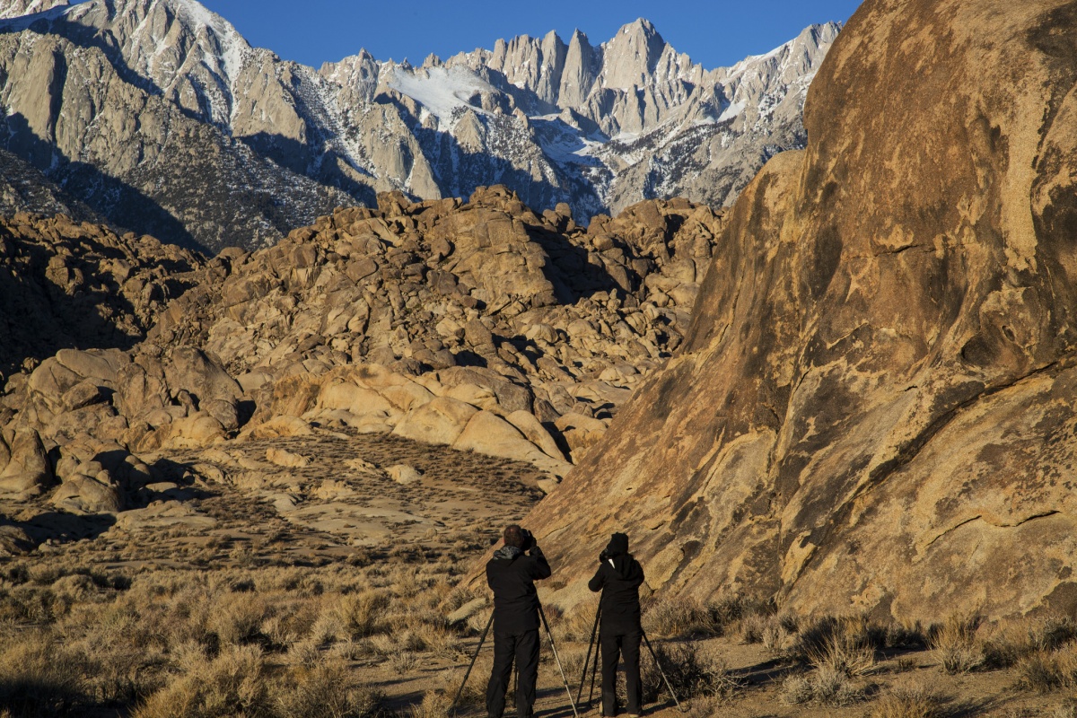 Two visitors photograph the mountains at Alabama Hills in California. Photo by Bob Wick, BLM.