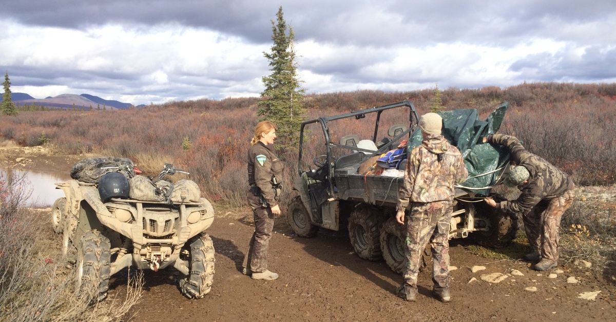 A BLM ranger helps two hunters.
