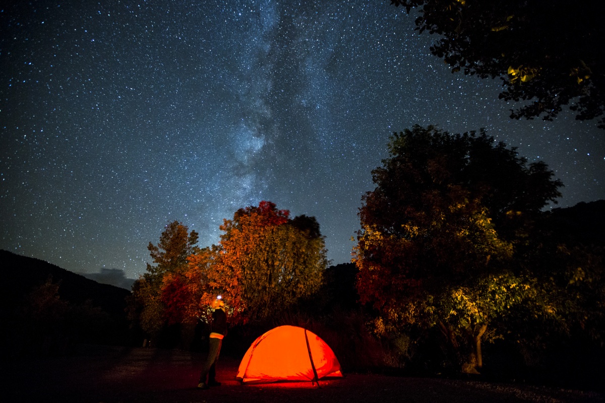 A women stands near her tent and admires the milky way in New Mexico. Photo by Bob Wick, BLM.