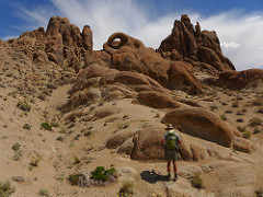 A hiker explores the rounded, weathered contours of unique rock formations at the Alabama Hills.  Photo by David Kirk, BLM.