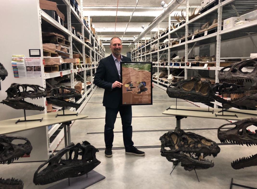 Paleontologist poses with GSENM Poster