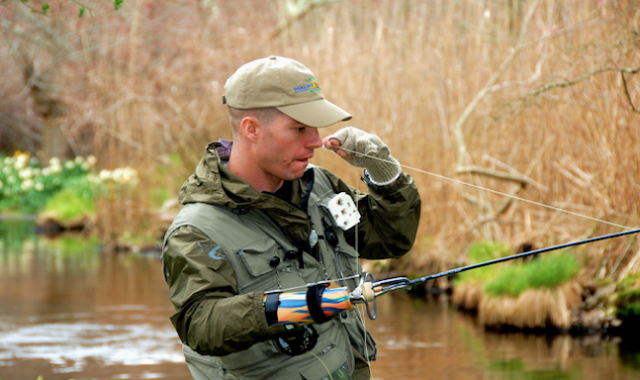 A Veteran fly fishing at a lake with arm disability during the Alaska Project healing waters event