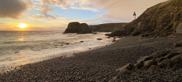 Yaquina Head Outstanding Natural Area showing Pacific Ocean on Cobble Beach and orange sunset on the horizo