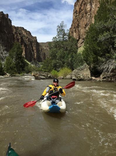 Rich kayaking in river canyon