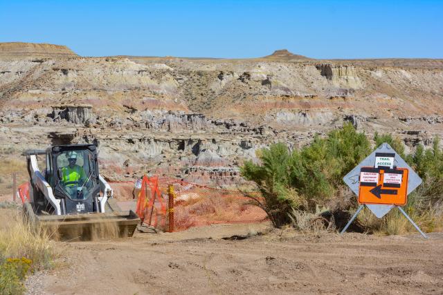 Construction signs and heavy equipment show that there is construction underway at a scenic area in the badlands.