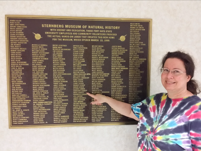 Cami points out her and Greg’s names on a plaque giving credit to those who helped establish the Sternberg Museum of Natural History’s new location near Interstate 70 in Hays, Kansas.