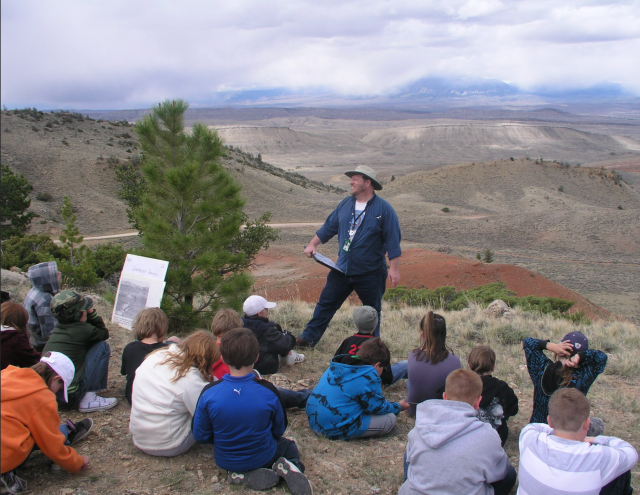 As the Montana/Dakotas State Paleontologist, Greg leads a field trip for youth and families overlooking Red Dome near Bridger, Montana. 