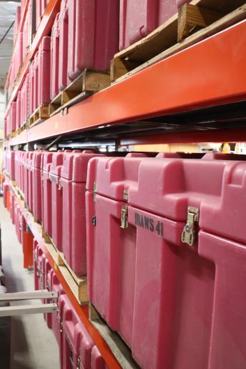 Long shelves full of large red plastic cases labeled "IRAWS"