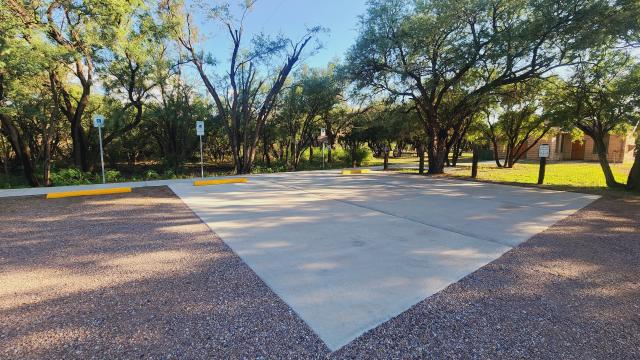 A concrete path leads to paved parking spaces.