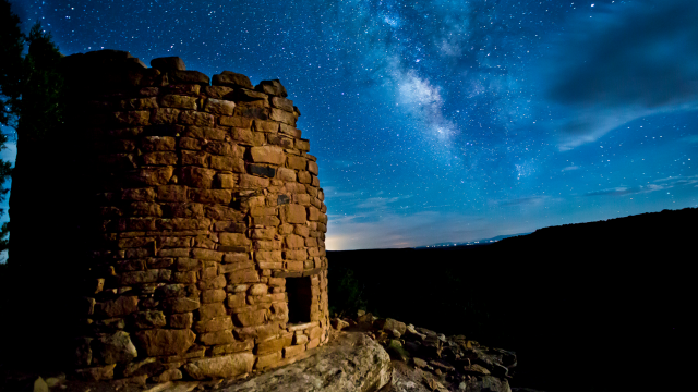 Ancient building illuminated against night sky.