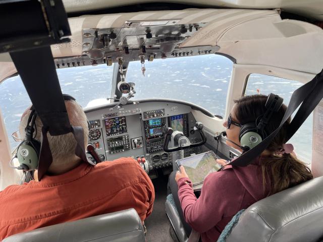 A man and woman inside a flying helicopter