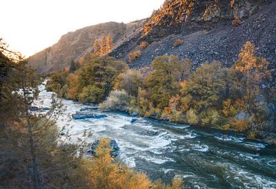 A river at sunset between two steep cliffs.