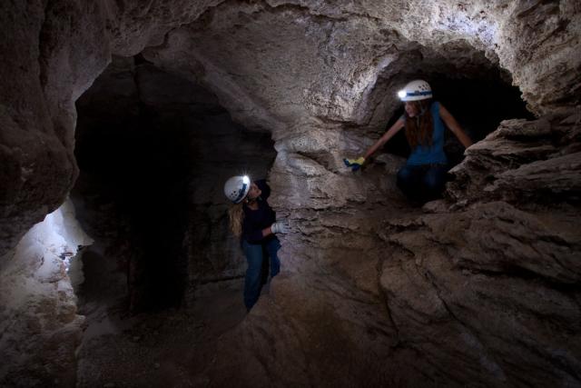 Two visitors with head lamps on in Parks Ranch Cave.