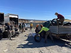 People unloading used tires.