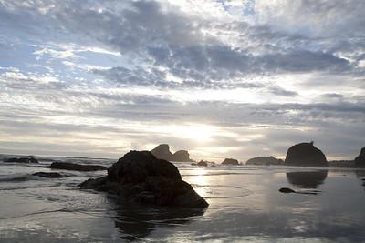 Large rocks and islands under a cloudy sky.