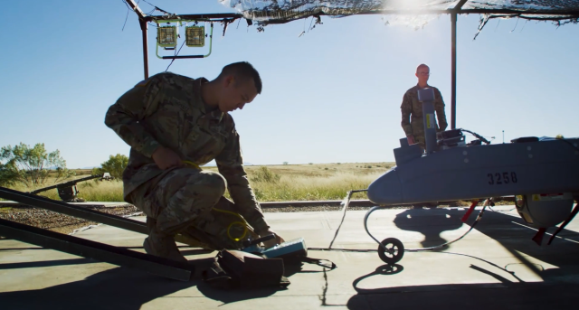 soldiers work on drone equipment