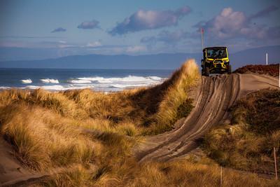 An OHV climbs a coastal dune.