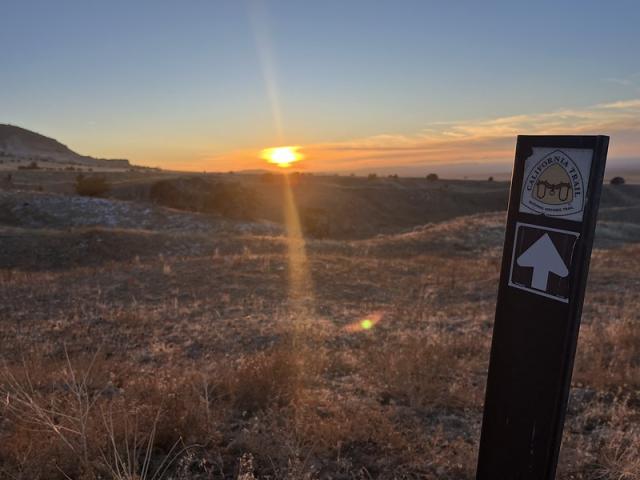 A sign marker for the California Trail at Hastings Cutoff at sunset.