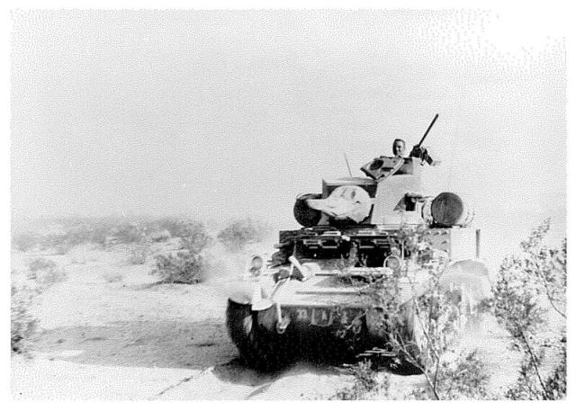 A tank rolls through a flat desert