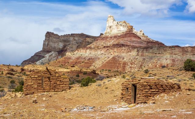Two historic structures with the backdrop of Temple Mountain, Utah.