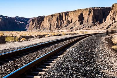 A rail line runs through a large canyon