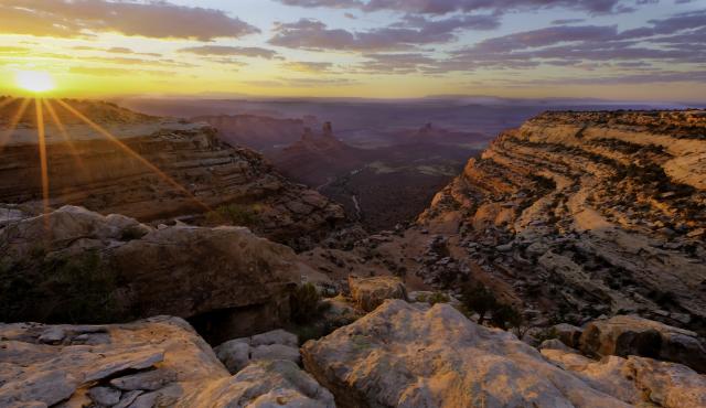 a sunrise over a rocky canyon