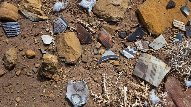 Pieces of broken pottery scattered on a rocky surface.