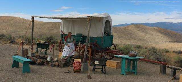 Oregon Trail wagon encampment with re-enactors showing the pioneer experience