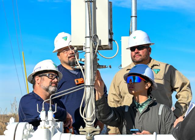 Four Petroleum Engineering Technicians are inspecting equipment. 