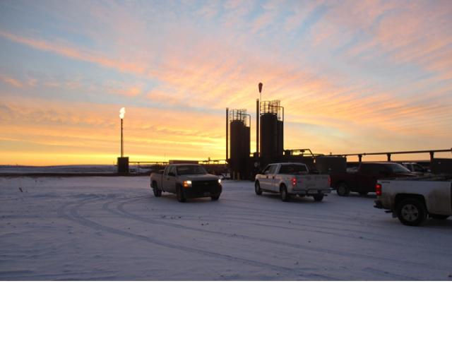Photo of oil and gas rigs during sunset.