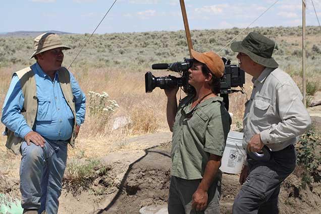 Archaeologist speaking outdoors to a film crew