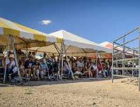 Eager adopters sitting in stands await the start of a wild horse and burro adoption event. 