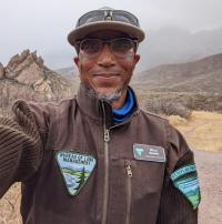 BLM park ranger selfie in front of mountains