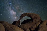 An arched rock with the night sky. 