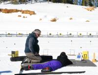 A youth participant learns how to shoot using an electronic rifle during winter adventure day