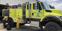 A bright yellow fire engine says "BLM Fire WY-WBD" on the side.