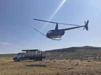 A helicopter takes off after fueling up from a fuel truck.