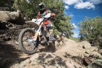 A motorcycle rider tackles a trail on public land.