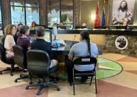 a photo of five people sitting in front of a Tribal council