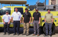 Five men stand in front a type 6 fire engine during transfer ceremony.