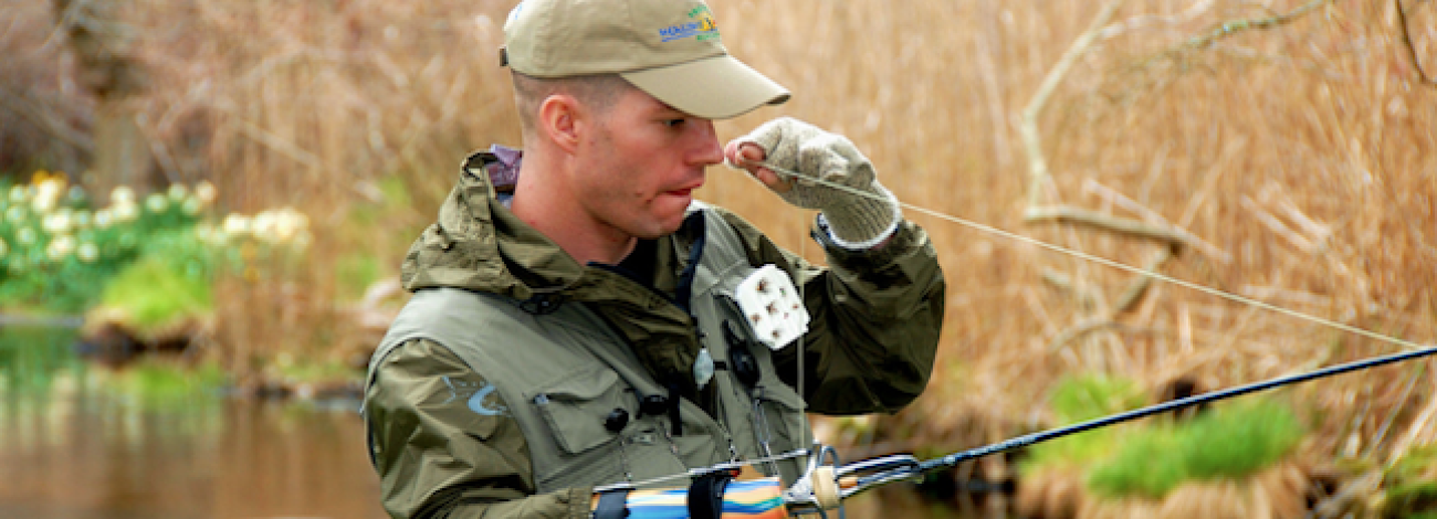 A Veteran fly fishing at a lake with arm disability during the Alaska Project healing waters event