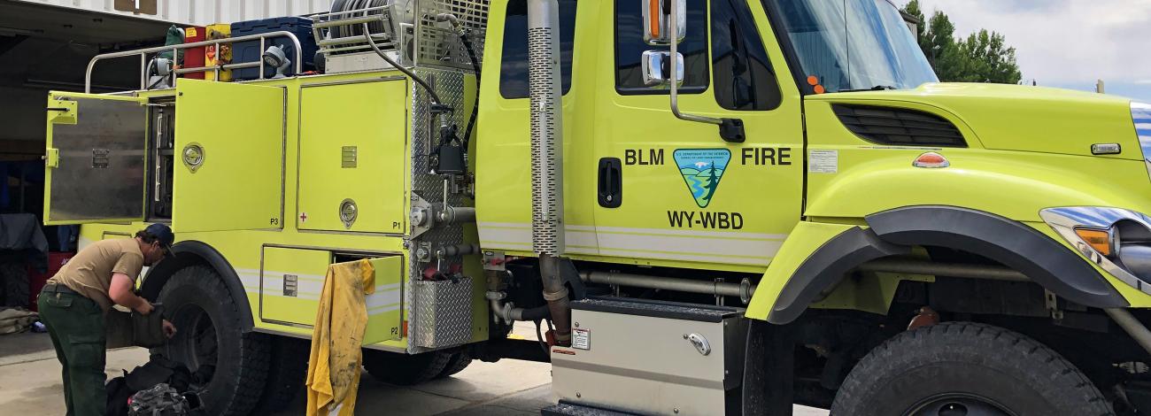A bright yellow fire engine says "BLM Fire WY-WBD" on the side.