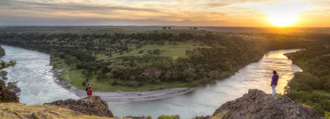 Two hikers overlooking Scremento River bend.