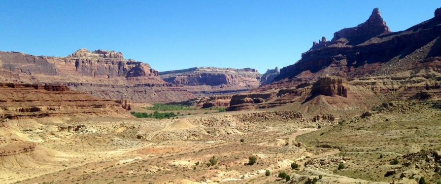 Brightly colored cliffs, buttes, ridges, alcoves, and pinnacles on a sunny blue sky day