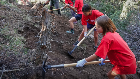 Young volunteers cleaning up a trail