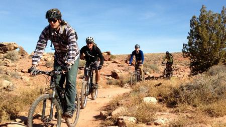 Four mountain bikers on the Bar M Trail System in Moab, Utah.